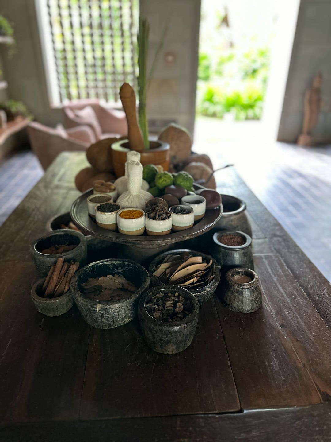 Natural spa ingredients and herbal compresses arranged on a wooden table.